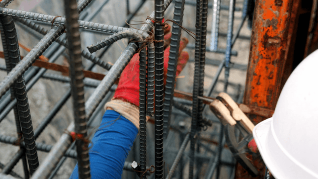 Worker welding steel bars at a construction site