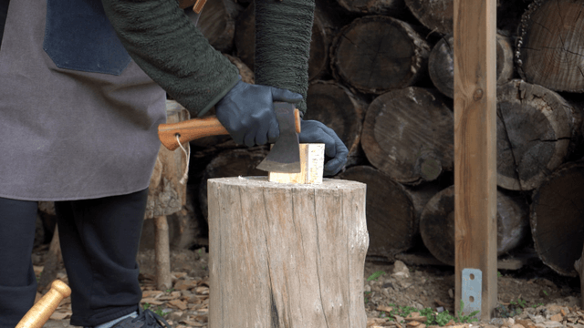 Person chopping wood with an axe outdoors