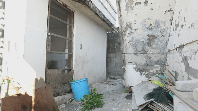 Old alley with peeling walls and debris