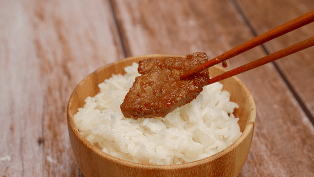 Bowl of rice with a piece of marinated meat