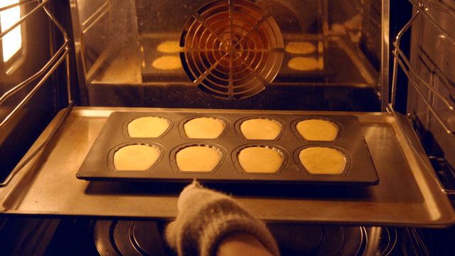 Madeleine batter tray placed into oven