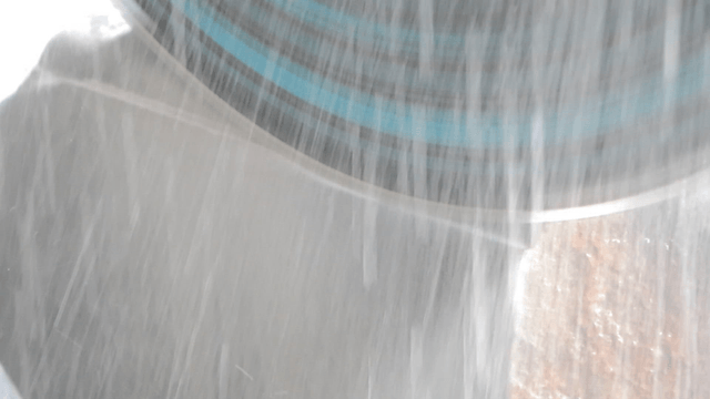 Delicate industrial saw cutting stone with water spray