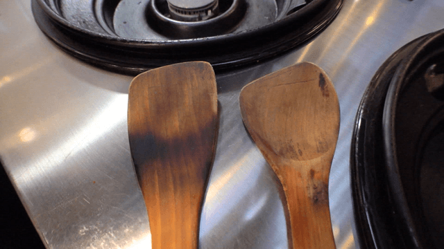Old wooden spatulas on kitchen stove