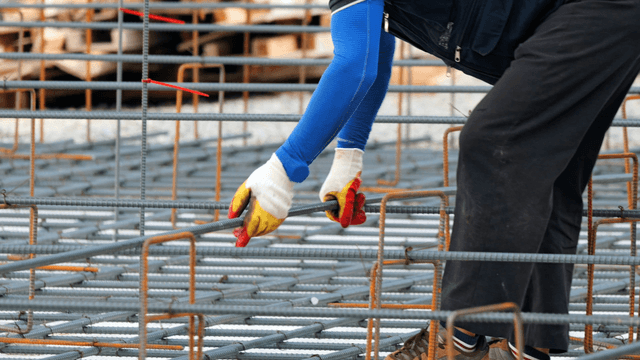 Worker assembling steel bars at a construction site