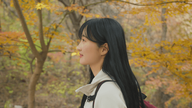 Woman walking through autumn foliage forest
