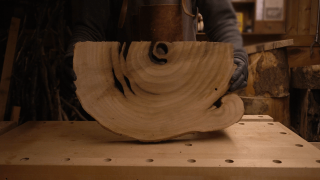 Woodcraft artisan handling wooden boards in workshop