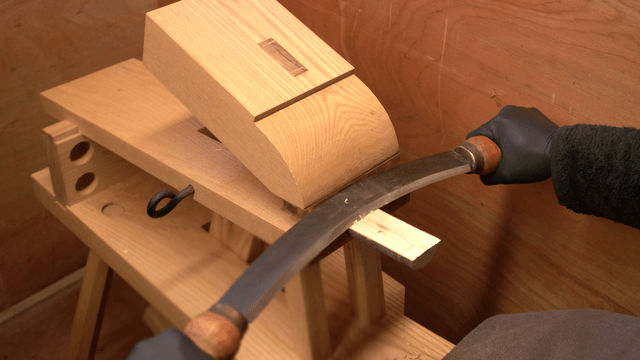 Woodworking with a drawknife in a workshop
