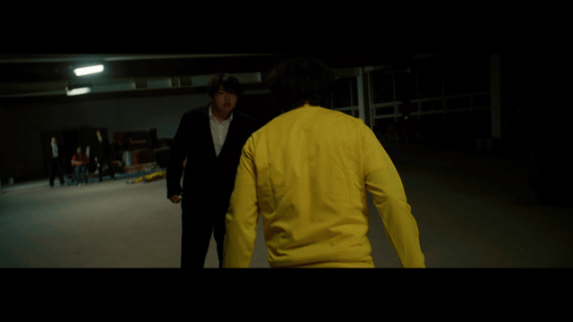 Two men fighting in a dimly lit room