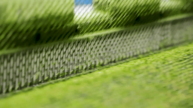 Green artificial turf being made on machine