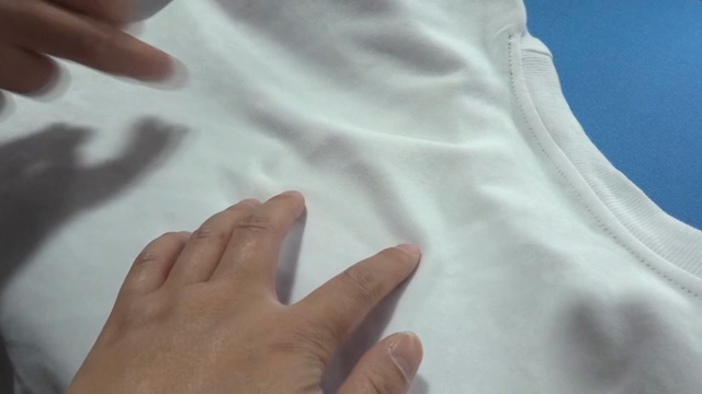 Hands inspecting a white fabric