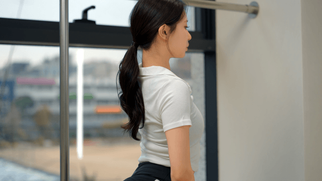 Woman stretching indoors by a window