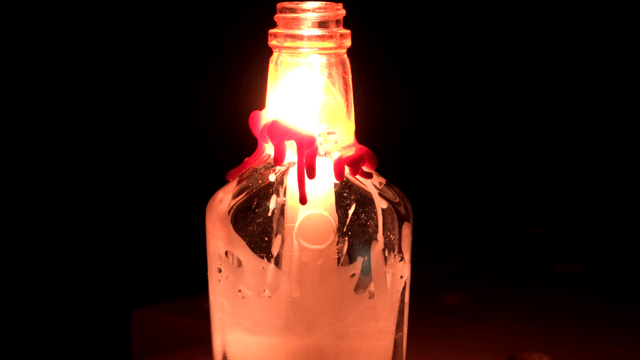 Candle burning inside a glass bottle