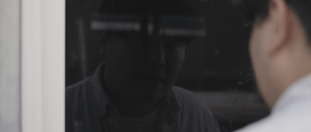 Person looking at their reflection in a window