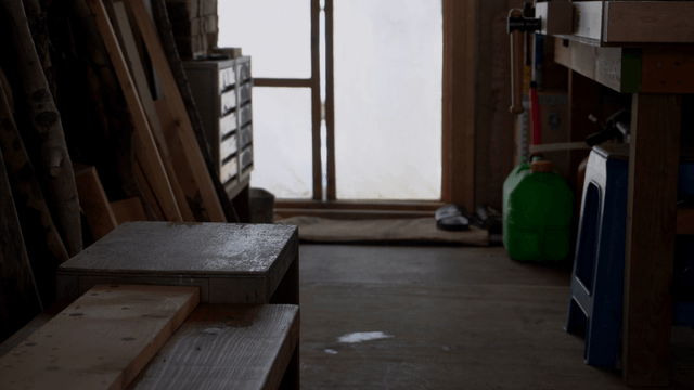 Person wearing hiking shoes leaving the woodworking workshop