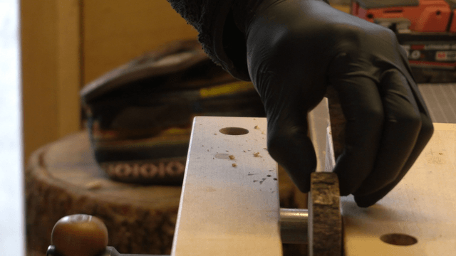 Hand placing wooden blocks into a vise