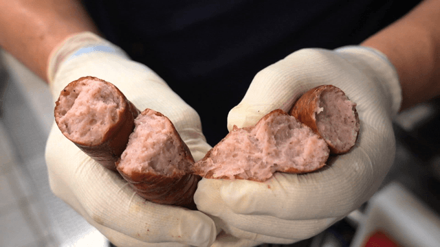 소시지를 가르는 장갑 낀 손