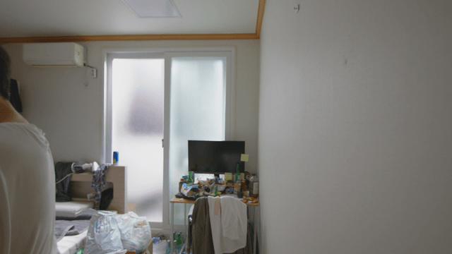 Man catching a bug in a messy room