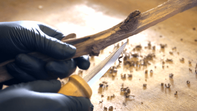 Hands carving wood with precision