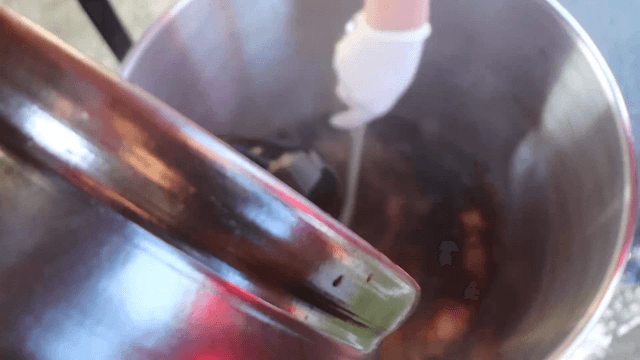 Pouring soy sauce into a large pot