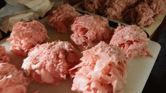 Piles of shaved ham on a cutting board