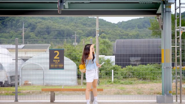 기차역 플랫폼에서 기다리는 여성