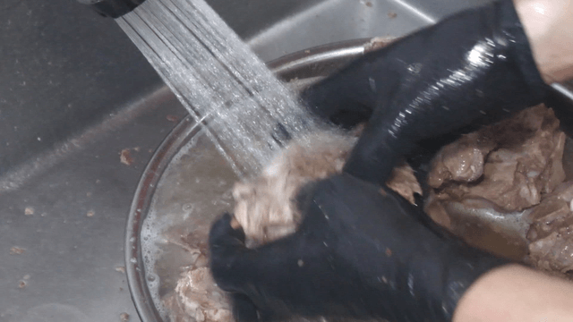 Boiled meat being washed under running water