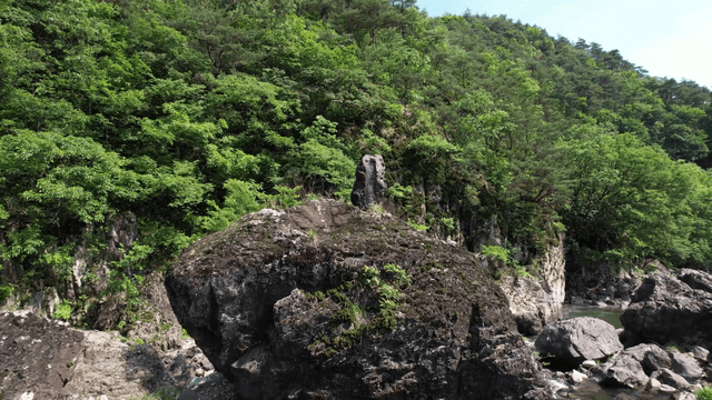계곡과 푸른 숲으로 둘러싸인 바위