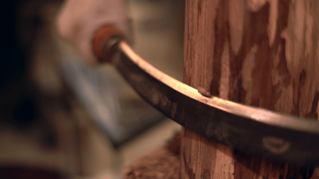Wood being carved with a hand tool