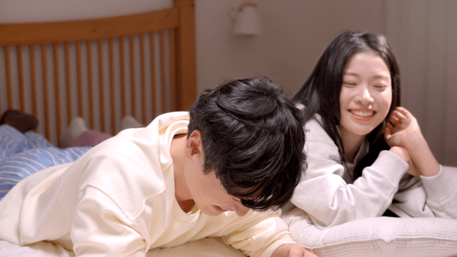 Couple talking and smiling while lying in bed