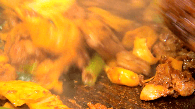 철판 위로 야채와 함께 볶아지는 닭갈비