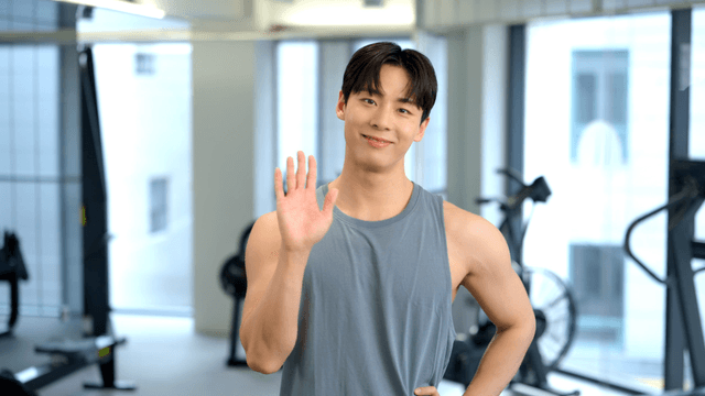 Man smiling and waving in a gym
