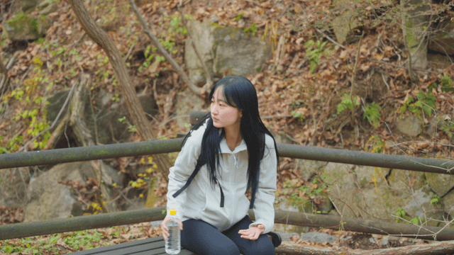Woman resting on bench along hiking trail