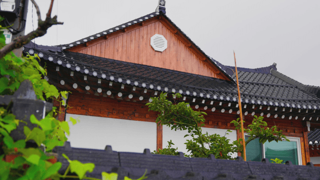 Traditional hanok covered with vines on an overcast day