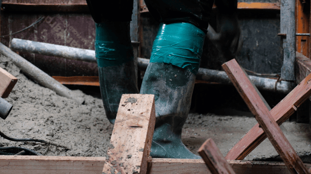 Worker in rubber boots at a construction site