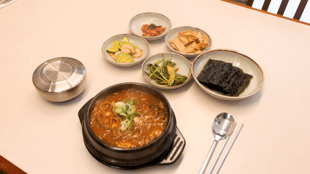 Kimchi stew and side dishes on restaurant table