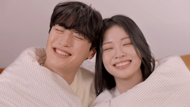 Happy couple smiling wrapped in blanket