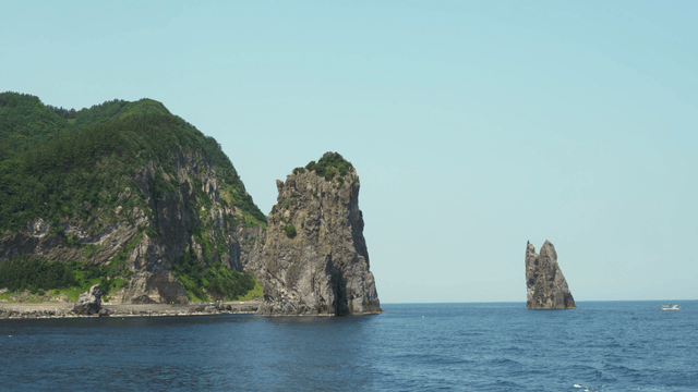 Rocky cliffs and sea with a distant boat