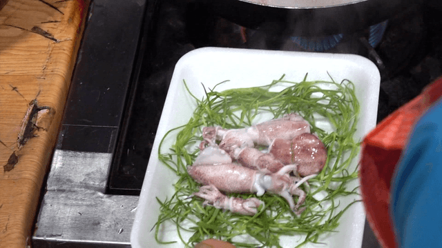 Parboiled baby octopus placed on plate with seaweed
