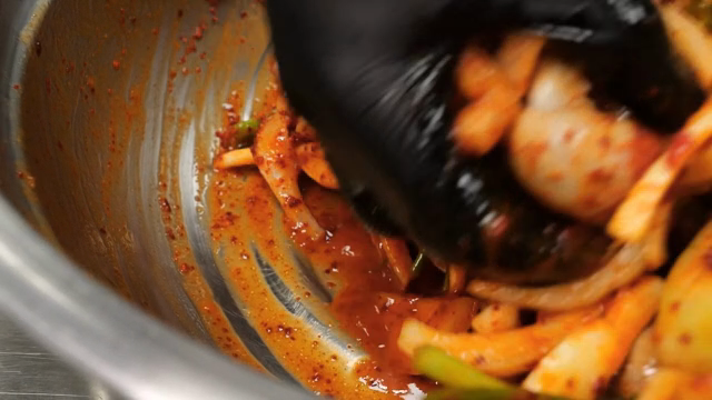 각종 채소를 매운 양념에 버무리는 손