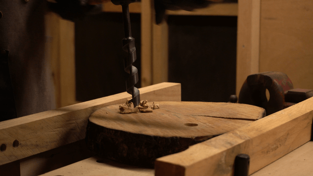 Artisan drilling wood in workshop