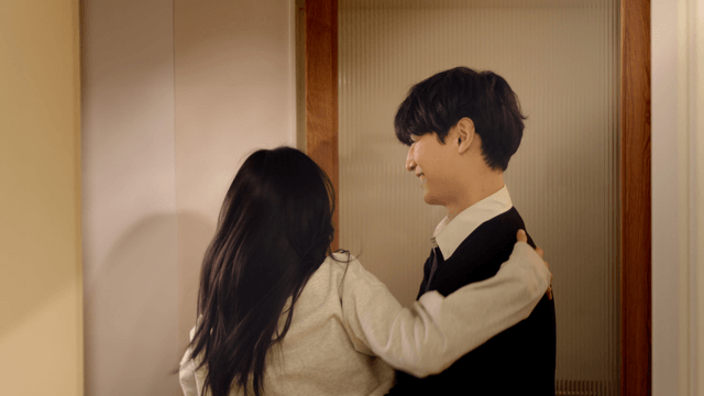 Welcoming woman greeting man at doorway