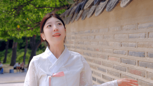 전통 벽을 감상하는 한복 입은 여성