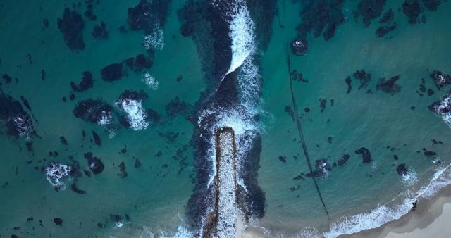 Waves crashing on a rocky pier
