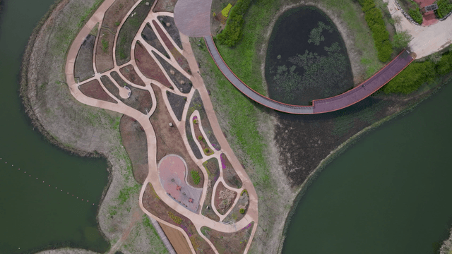 Landscaped lake park with walking paths, aerial view
