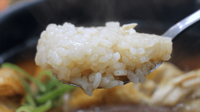Spoon lifting glutinous rice from phellinus linteus ginseng chicken soup