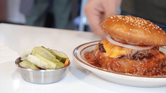 A burger and pickles on a table