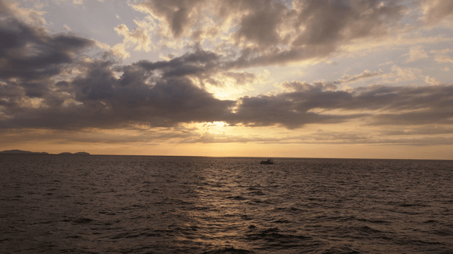 멀리 섬이 보이는 바다 위의 일몰