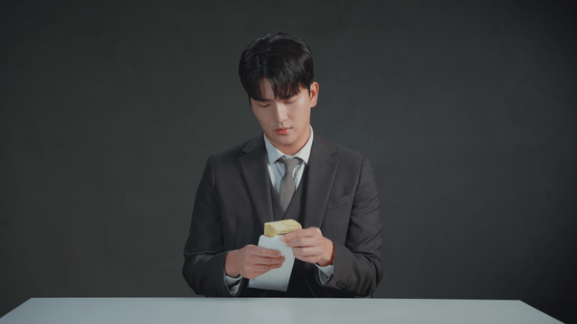 Man in a suit counting money at a table
