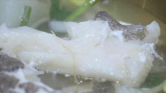 Chopsticks picking up cod soup fillet