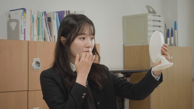 Student checking appearance in a mirror